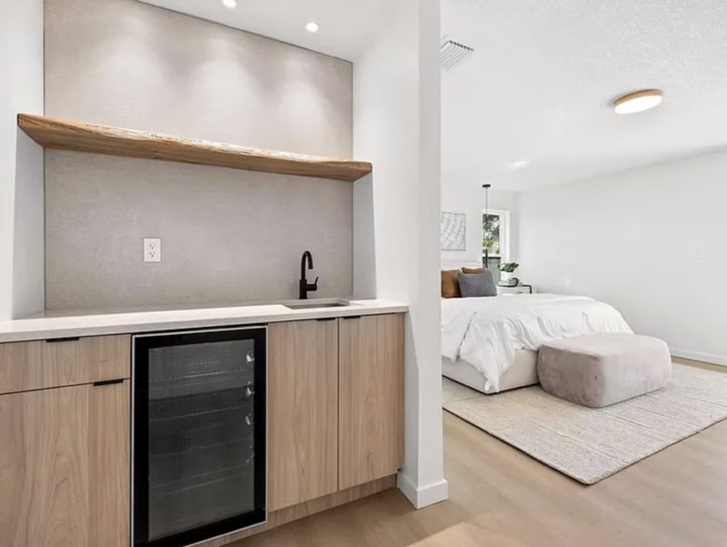 Home remodel in Clearwater, FL with an oak wet bar and beverage fridge opening into the primary bedroom