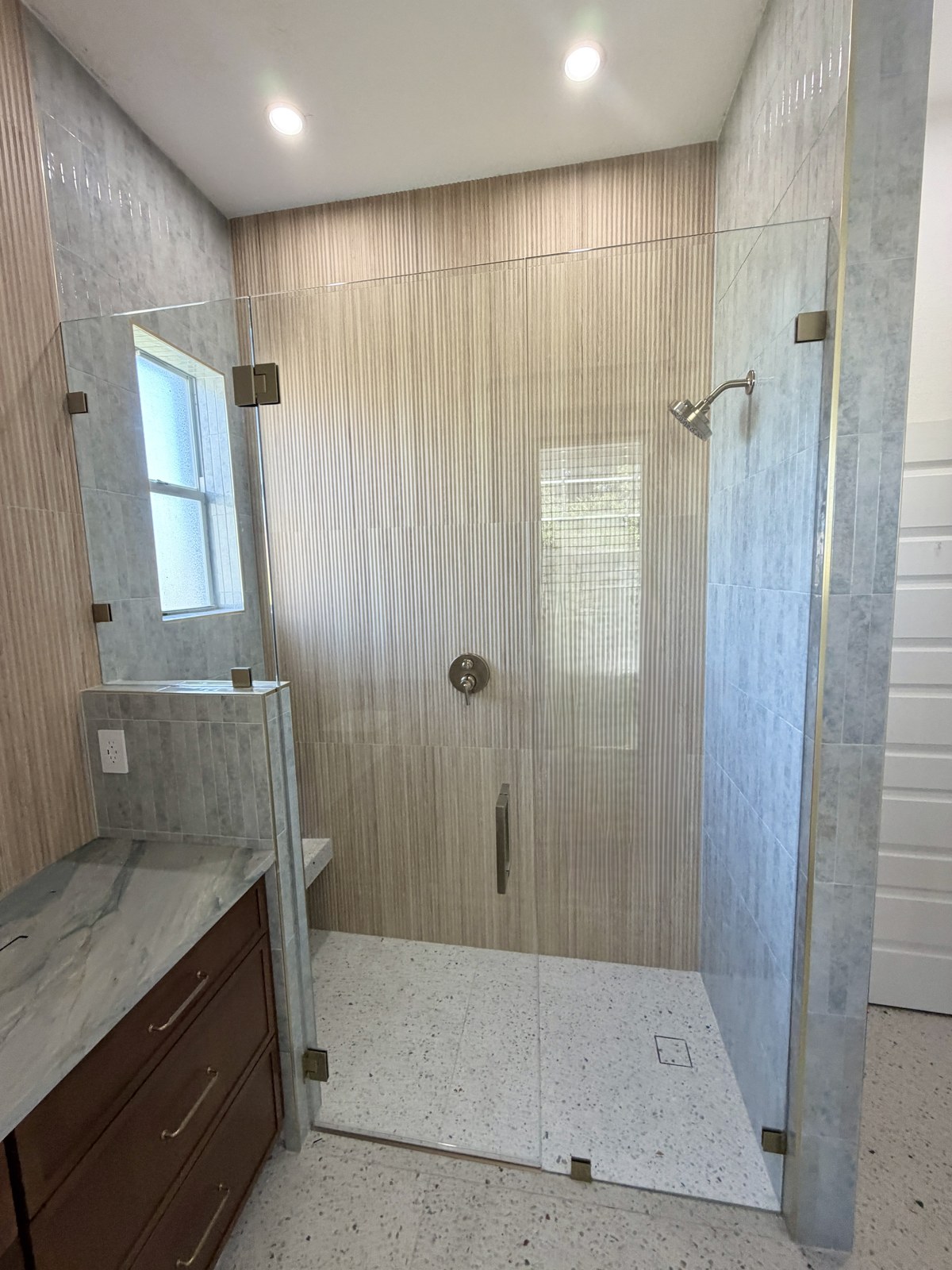 Walk-in shower with bench and window