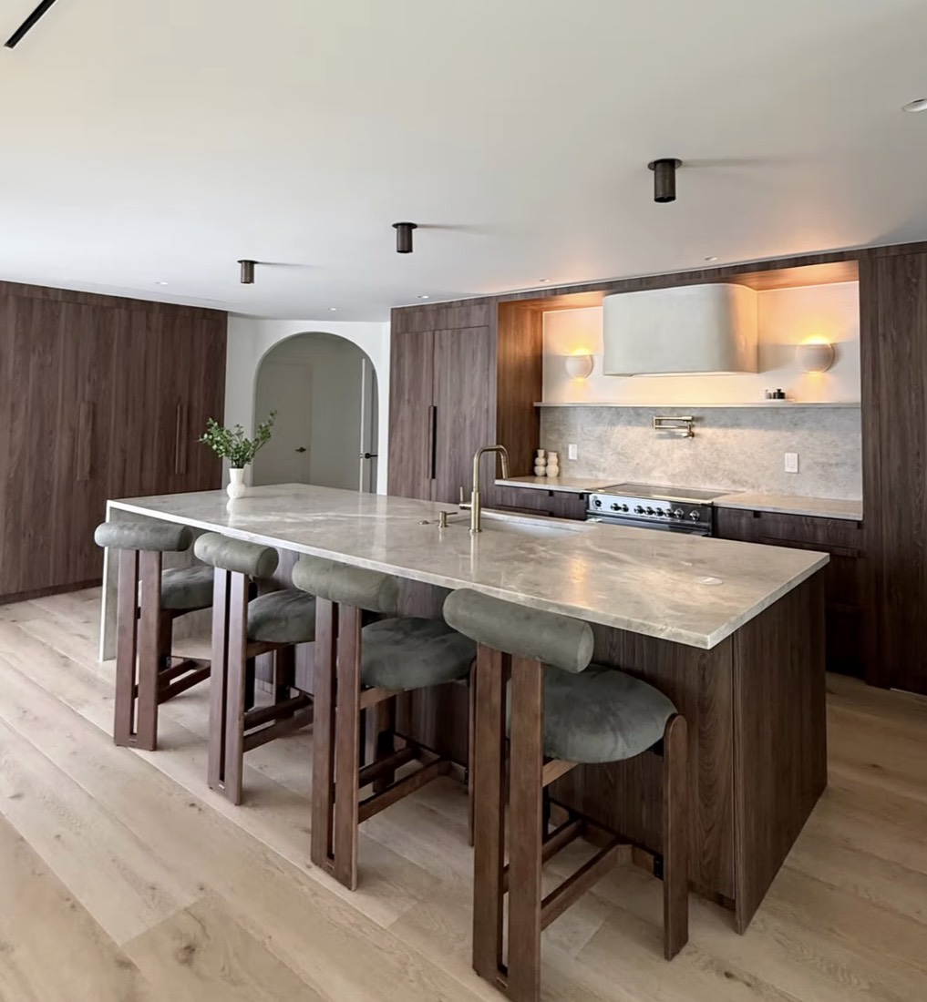 Kitchen remodel in St. Petersburg, FL with full-height walnut cabinetry and a stone island seating four